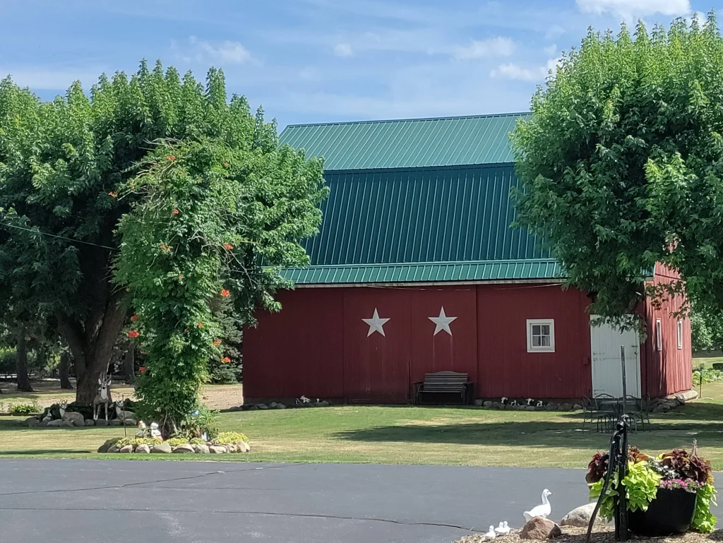 Green Metal Roof on Red Barn with Stars - COnroe Roof Maven Red Barn Conroe Roofing